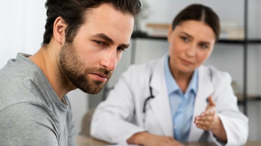 A doctor giving news to a man who has a very sad expression on his face