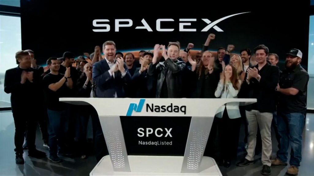 Elon and several people celebrating during an interview after the positive news of SpaceX's stock market debut