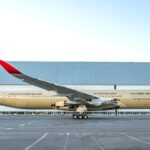 The impressive aircraft seen from one side, showcasing its beautiful gold and white colors