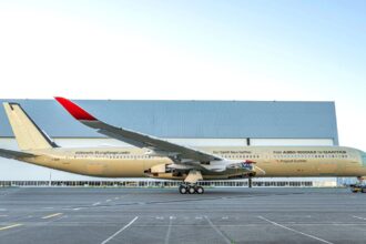 The impressive aircraft seen from one side, showcasing its beautiful gold and white colors