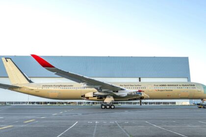 The impressive aircraft seen from one side, showcasing its beautiful gold and white colors