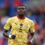 The Ghanaian player in the middle of a match wearing his yellow national team jersey