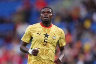 The Ghanaian player in the middle of a match wearing his yellow national team jersey