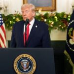 Trump speaking in public while wearing an elegant suit and a very serious expression