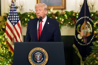 Trump speaking in public while wearing an elegant suit and a very serious expression