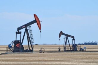 A panoramic view of two oil drilling rigs with a beautiful background