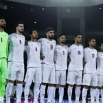 The Iranian national team players embracing each other while singing their country's national anthem