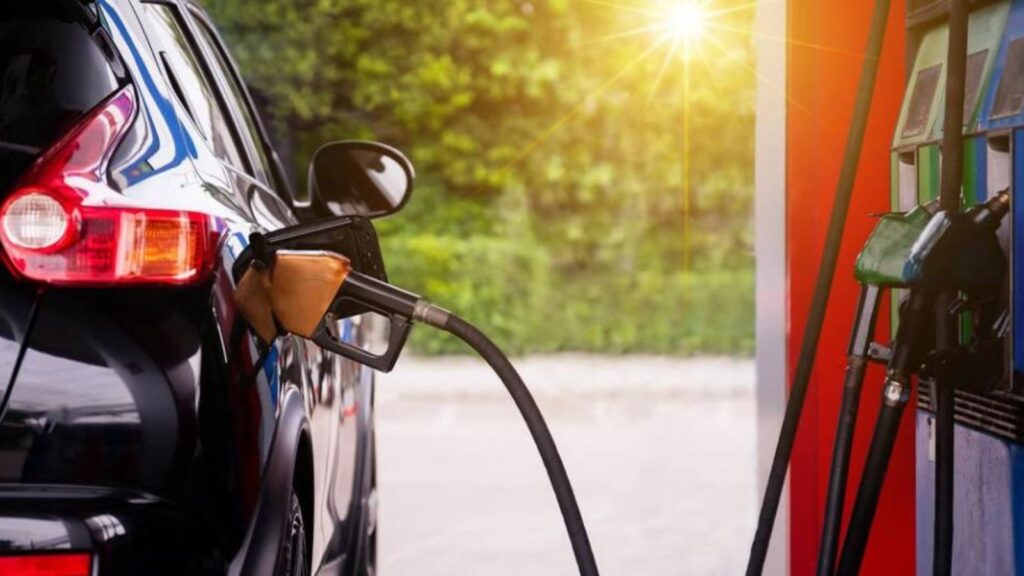 A car being refueled at a gas station with sky-high fuel prices