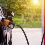 A car being refueled at a gas station with sky-high fuel prices