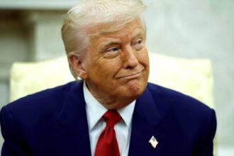 Donald Trump smiling sarcastically while looking to the side at one of his aides