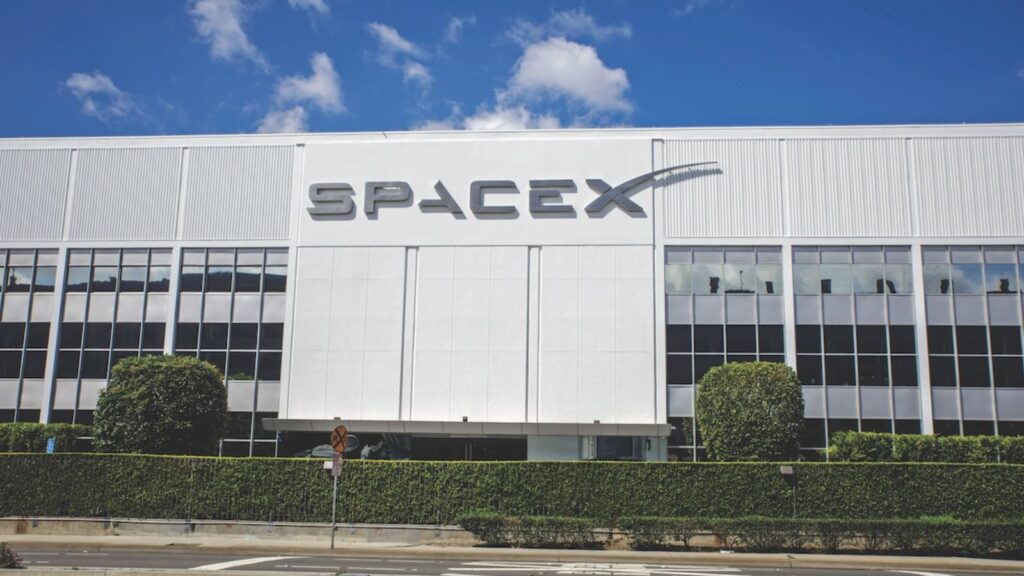 One of SpaceX's white office buildings with its name prominently displayed on the front