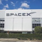 One of SpaceX's white office buildings with its name prominently displayed on the front