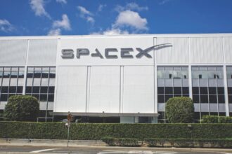 One of SpaceX's white office buildings with its name prominently displayed on the front