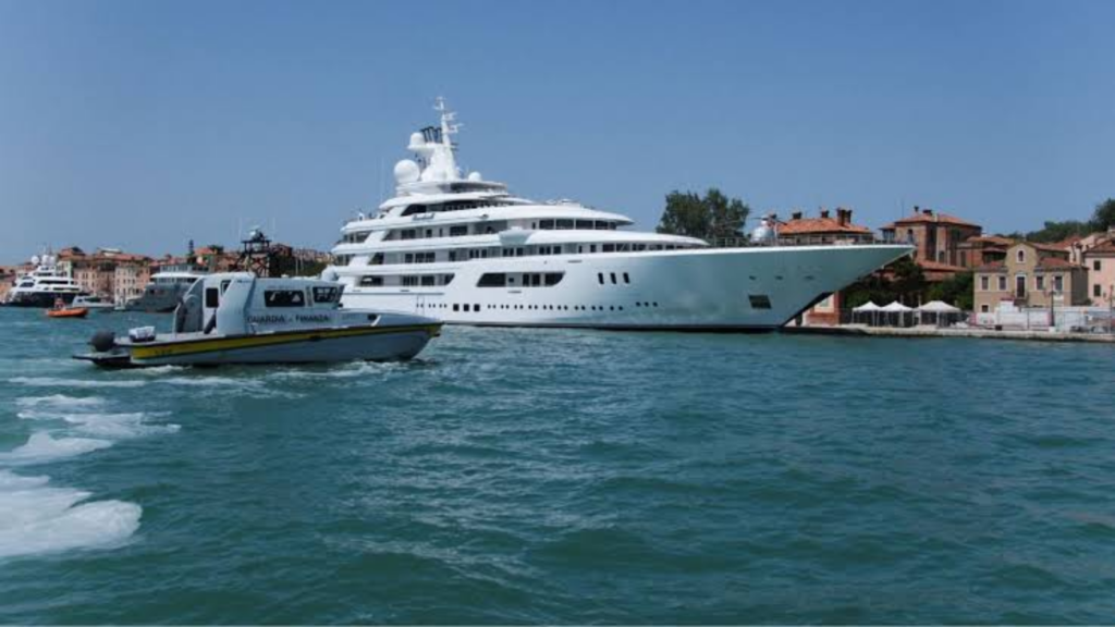 A luxurious white yacht docked at a small harbor in the city of Venice, Italy
