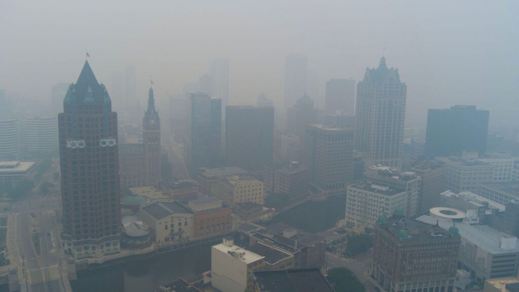 A panoramic view of New York where buildings and houses are shrouded in a thick cloud of pollution and smoke
