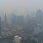 A panoramic view of New York where buildings and houses are shrouded in a thick cloud of pollution and smoke