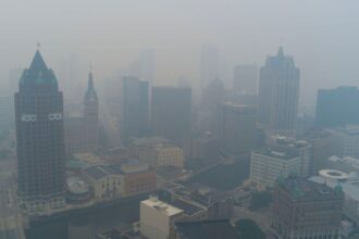 A panoramic view of New York where buildings and houses are shrouded in a thick cloud of pollution and smoke