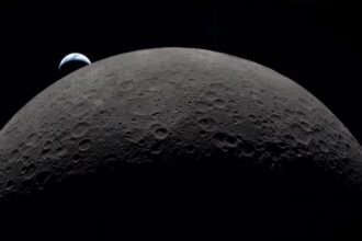 A view from the Moon showing planet Earth rising behind the lunar surface