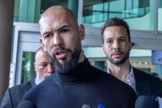 The Tate brothers walking while surrounded by numerous members of the media seeking information from them