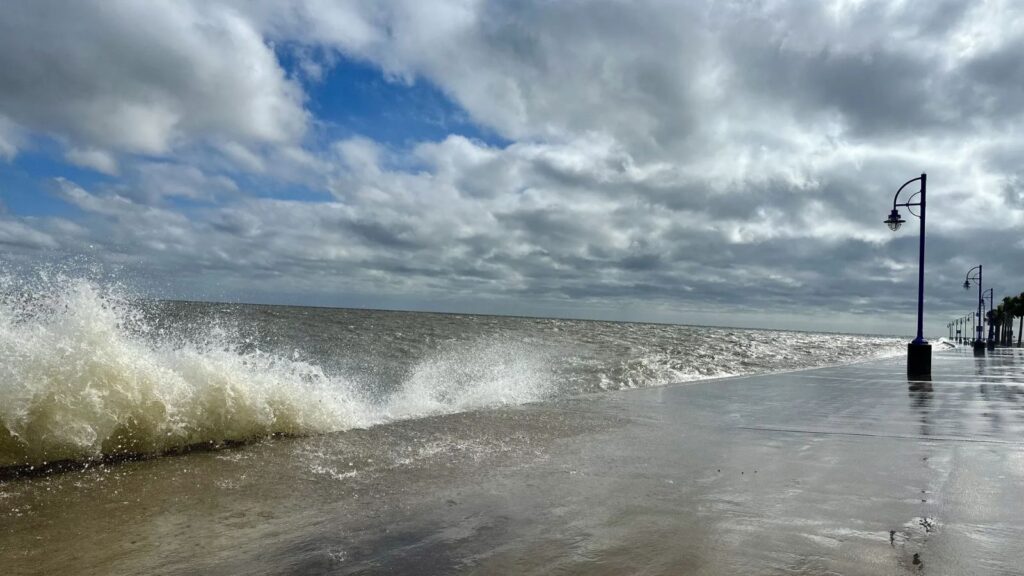 Bertha weakens but leaves Its mark across the southern United States A beach being violently battered by waves crashing against a seawall, creating a tense and unsettling atmosphere