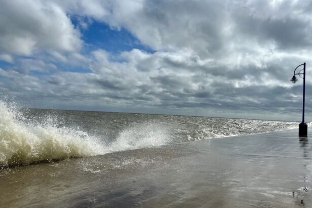 A beach being violently battered by waves crashing against a seawall, creating a tense and unsettling atmosphere