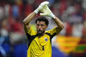 The veteran goalkeeper applauding with his arms raised after achieving a remarkable feat with his national team