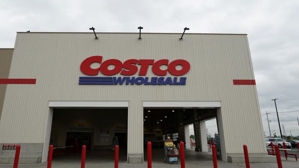Costco nder fire: Class-action lawsuit raises concerns over popular protein powders A Costco store viewed from the front, with several customers walking outside while pushing shopping carts