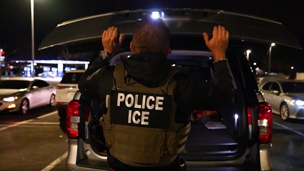 Death of Colombian man during ICE operation sparks calls for answers in the United States An ICE officer in uniform inspecting the trunk of a parked car