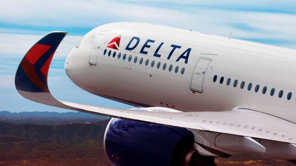 Delta unveils a new way to fly first class for less The front of a white airplane with the word 'Delta' on one of its sides