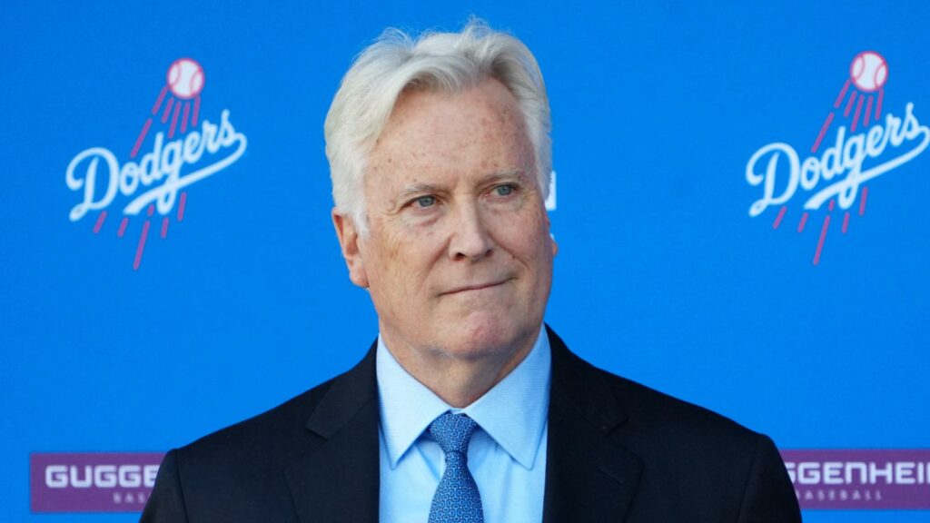 The owner of both Los Angeles franchises smiling at the camera during what appears to be a Dodgers presentation