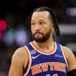 Brunson looking toward the fans during a game while wearing the New York Knicks' blue and orange uniform