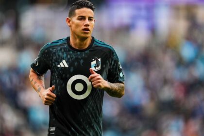 The Colombian midfielder running in his black uniform during a soccer match