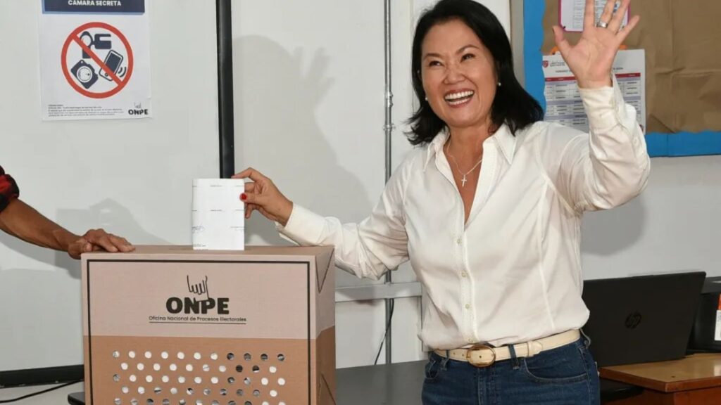 The newly elected President of Peru casting her ballot into the ballot box while smiling for the cameras