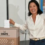 The newly elected President of Peru casting her ballot into the ballot box while smiling for the cameras