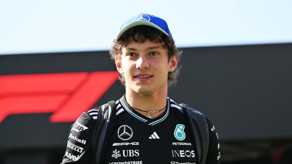 Kimi Antonelli conquers belgium and makes a powerful statement in Formula 1 The young Formula 1 driver walking with the trophy in his hand, wearing his striking black racing suit and a matching black cap