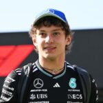 Kimi Antonelli conquers belgium and makes a powerful statement in Formula 1 The young Formula 1 driver walking with the trophy in his hand, wearing his striking black racing suit and a matching black cap