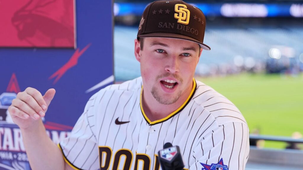 Miller speaking into a microphone in front of numerous media outlets while wearing his San Diego uniform with an All-Star Game patch
