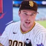 Miller speaking into a microphone in front of numerous media outlets while wearing his San Diego uniform with an All-Star Game patch