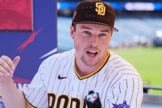 Miller speaking into a microphone in front of numerous media outlets while wearing his San Diego uniform with an All-Star Game patch