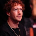 Mark with a slightly concerned expression during a conference surrounded by a large audience