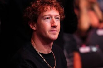 Mark with a slightly concerned expression during a conference surrounded by a large audience
