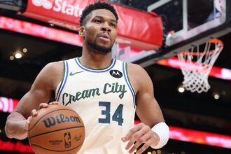 The Greek Freak holding a basketball with one hand