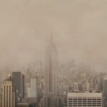 A panoramic photograph of New York City covered by pollution so dense that it blocks out the sunlight