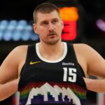 Jokić adjusting his uniform before the start of a basketball game