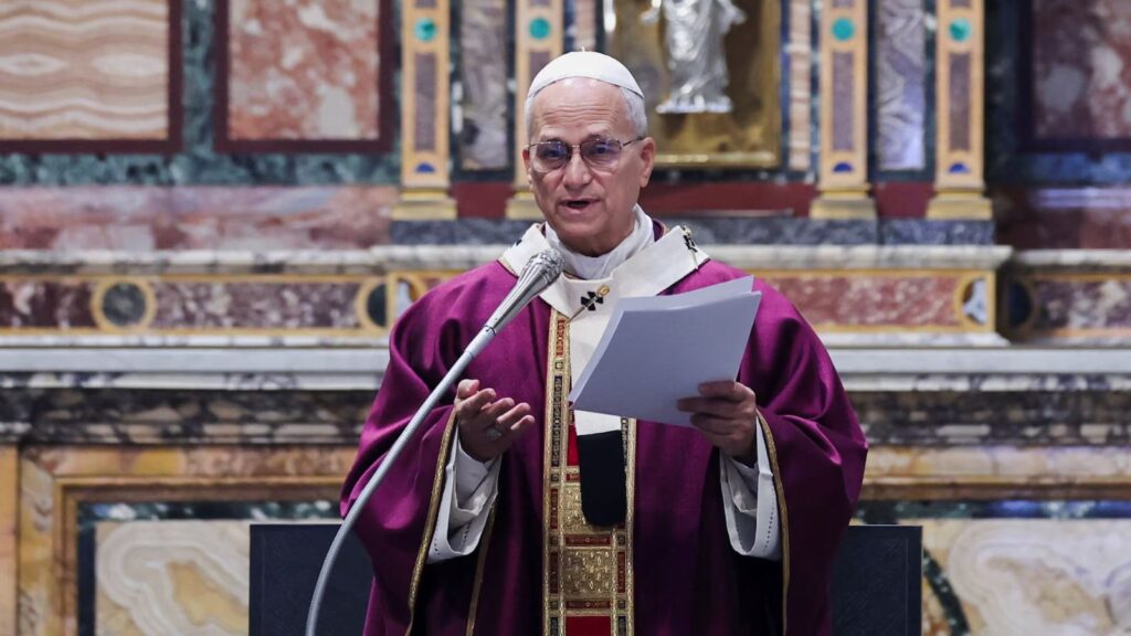 The current Pope speaking into a microphone to the people gathered at the church