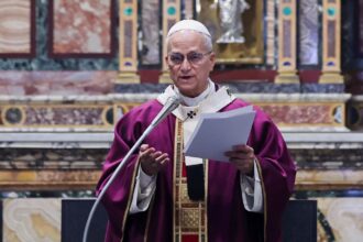 The current Pope speaking into a microphone to the people gathered at the church