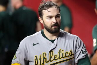 The star player walks into his team's dugout to prepare for his defensive inning