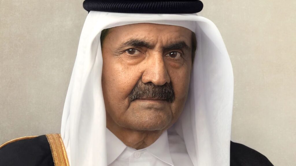 The leader of Qatar looking directly at the camera while wearing his country's traditional attire