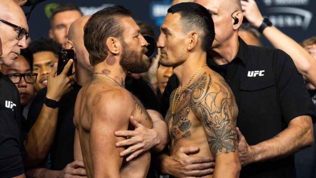 Shock in the UFC: Max Holloway stuns Conor McGregor with a dominant TKO victory Both fighters stare each other down face-to-face, surrounded by security to prevent the tension from escalating