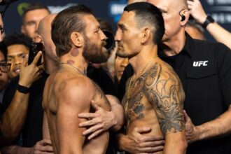 Both fighters stare each other down face-to-face, surrounded by security to prevent the tension from escalating